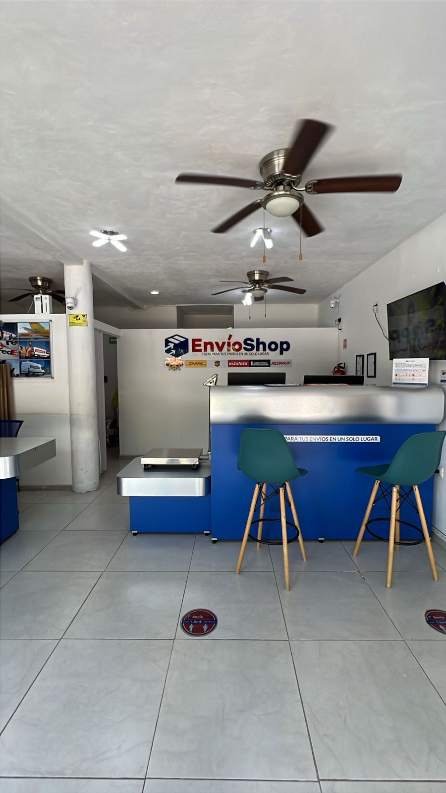Interior de EnvíoShop Cancún con mostrador de atención, báscula y asientos